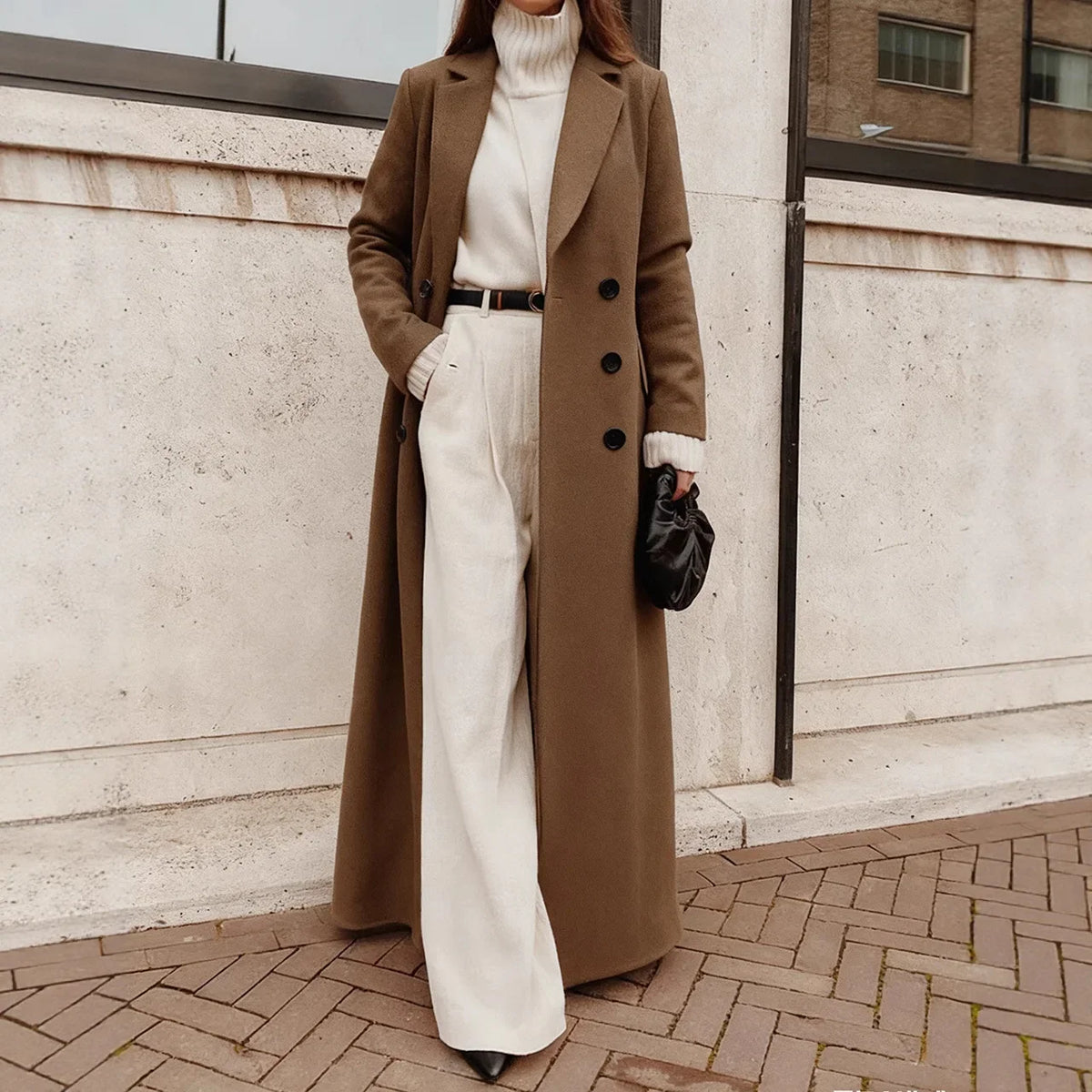 Woman wearing brown long trench coat over cream sweater and pants