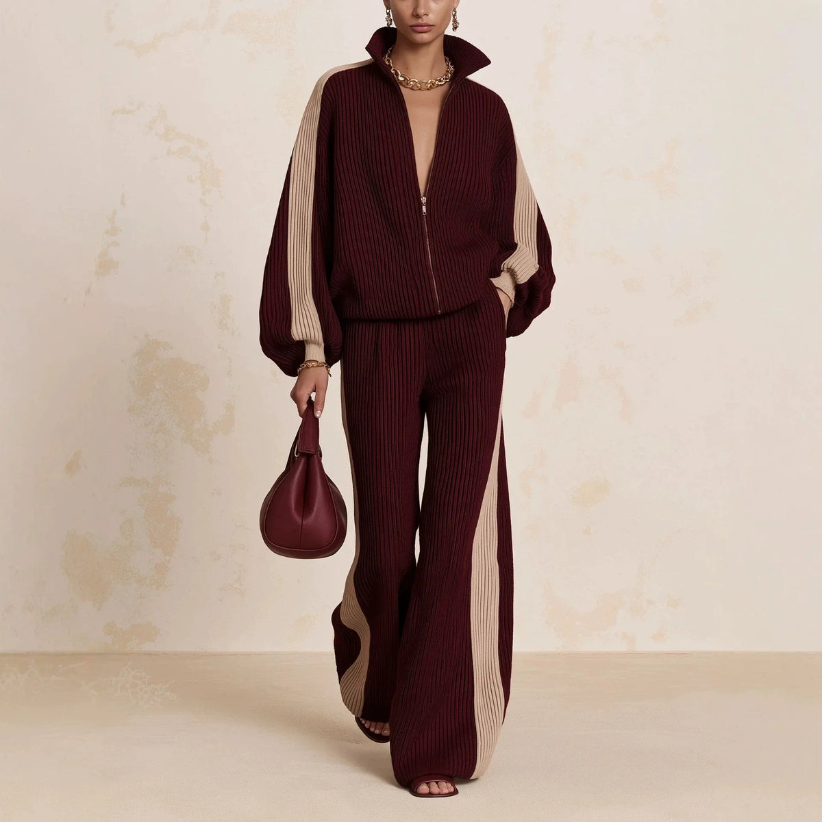 Woman wearing burgundy color block ribbed knit zip up top and wide leg pants matching set
