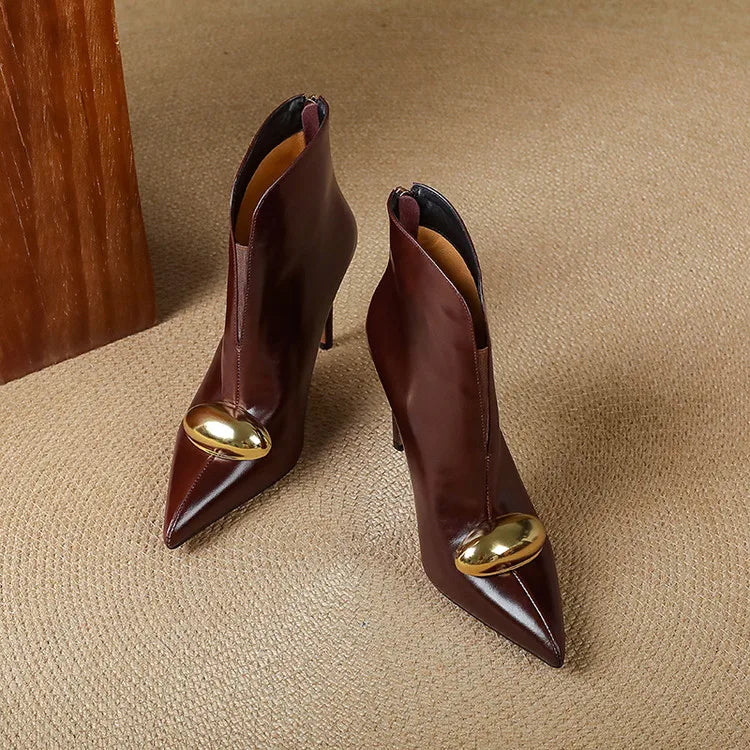 Pair of burgundy ankle boots with gold ornament, top view
